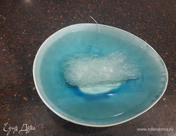 Займемся подготовкой к приготовлению. Для этого 1 пучок фунчозы кладем в глубокую тарелку и заливаем горячей водой. В таком состоянии лапшу нужно оставить на 5 минут. Количество воды зависит от размера вашей тарелки, поэтому не рекомендую использовать очень большую. Нужно, чтобы фунчоза полностью была залита водой.