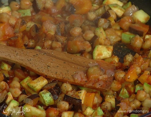 Добавить протертые помидоры и готовый нут, посыпать все перцем, тмином, еще раз перемешать и разложить в небольшие керамические формы для запекания.