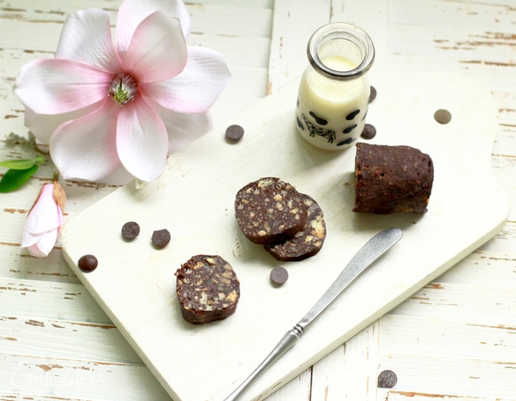 Измельчите подсохшие коржи (лучше вручную, чтобы контролировать величину крошки), смешайте с какао, добавьте крем, орешки и предварительно растопленное сливочное масло (40 г). Тщательно вымесите массу. Выложите на пищевую пленку, сформируйте колбаску и положите ее на 20–30 минут в морозилку, чтобы изделие схватилось. Далее храните в холодильнике.