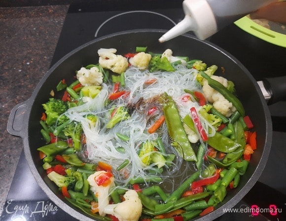 Добавляем соевый соус, два вида уксуса и остальные приправы в лапшу. Хорошо перемешиваем.