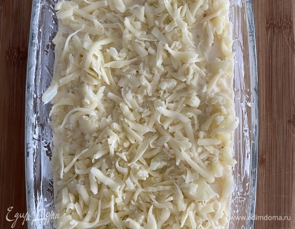 Полить капусту заправкой, перемешать, чтобы сыр полностью распределился в капусте. Посыпать сверху оставшимся сыром.