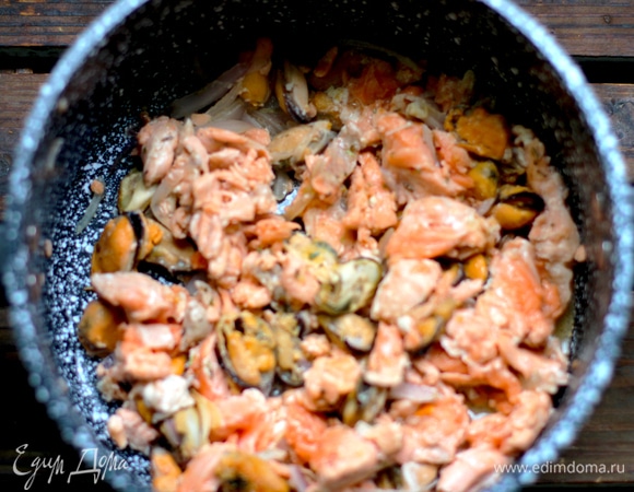 Обжариваем нашинкованный лук до прозрачности в оливковом масле. Добавляем рыбу и морепродукты, перемешиваем, вливаем вино и выпариваем на сильном огне.