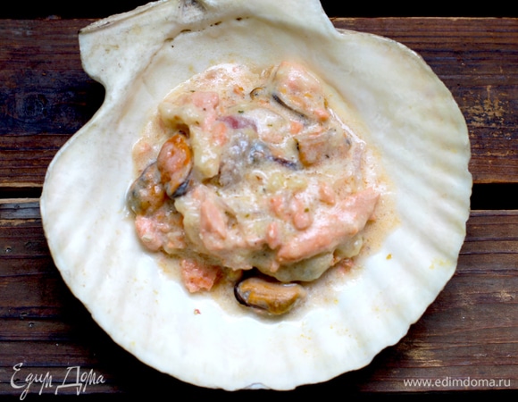 В подготовленные кокильницы кладем морепродукты со сливочной смесью. Духовку разогреваем до 200°C.