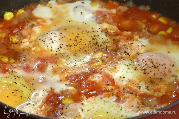 Яйца разбить в сковороду с овощами, посолить, поперчить, накрыть крышкой и прогревать до полуготовности, затем посыпать все тертым чеддером, накрыть крышкой и готовить еще 1–2 минуты.