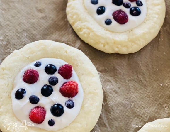 Достать полуготовые ватрушки, выложить творожную начинку и ягоды. Выпекать еще 15 мин при температуре 190–200°C.