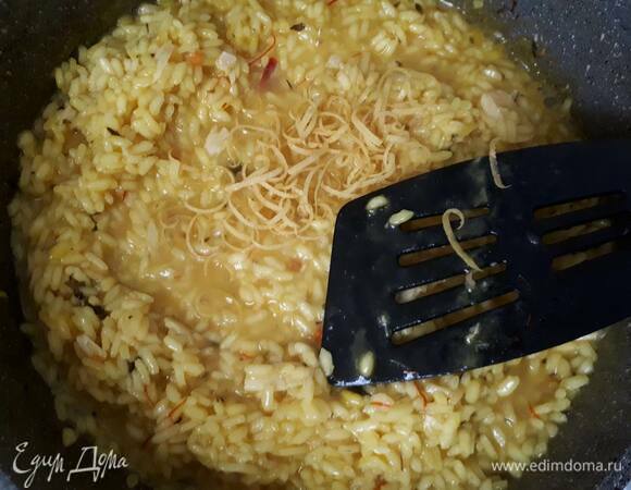 Когда останутся 1–2 половника бульона, добавьте цедру 1 лимона и сок половины лимона.