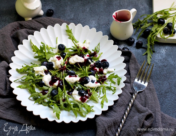Выложите листья руколы в салатницу, добавьте чернику и сыр. Полейте салат ягодным соусом.