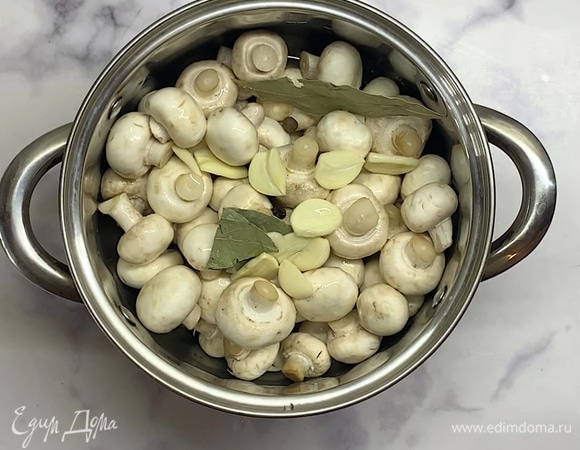 Шампиньоны тщательно моем и перекладываем в кастрюлю. Наливаем воду, добавляем соль, сахар, перец горошком, лавровый лист, гвоздику и чеснок, нарезанный лепестками.