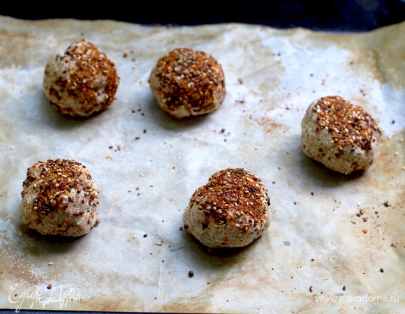 Творог протереть через сито (или использовать гладкий). Все ингредиенты смешать (желательно миксером) до однородности. В тесто по желанию добавить травы или сухой жареный лук. Мокрыми руками сформировать булочки, у меня получилось 5 шт. Верх посыпать кунжутом, кориандром или зерновой посыпкой для хлеба.