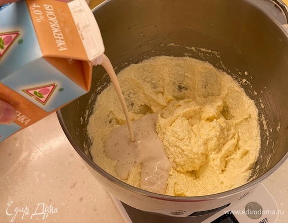 Масло взбить с сахаром в белый крем. По одному добавить яйца, перемешать. Добавить ряженку, хорошо перемешать.