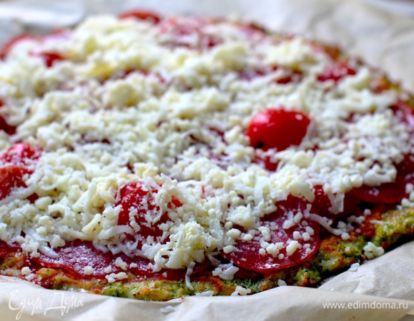 Ставим в разогретую до 200°C духовку, выпекаем 12–15 мин, до легкого зарумянивания. Достаем и выкладываем на подготовленную основу ингредиенты для топинга (я смазываю соусом, покрываю некоторым количеством моцареллы, потом выкладываю колбасу, черри и снова засыпаю моцареллой).