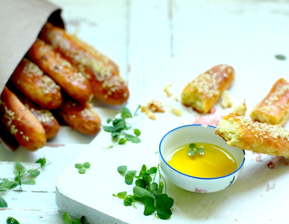 Пока палочки пекутся, приготовьте чесночный топинг: в оливковое масло выдавить чеснок, размешать. Достаньте палочки из духовки, смажьте чесночным маслом, посыпьте пармезаном и верните в духовку еще на 5 минут, готовьте до золотистой корочки.