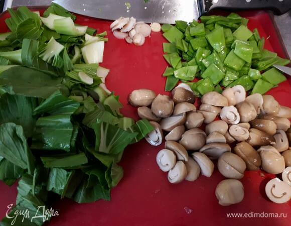 Нарежьте молодой горошек. Нарежьте соломенные грибы на половинки. У меня в рецепте кантонская капуста (или бок-чой). Можно использовать пекинскую капусту. В таком случае нужно взять половину кочана. У капусты отрежьте основание, удалите поврежденные листья, остальные листья крупно нарежьте.