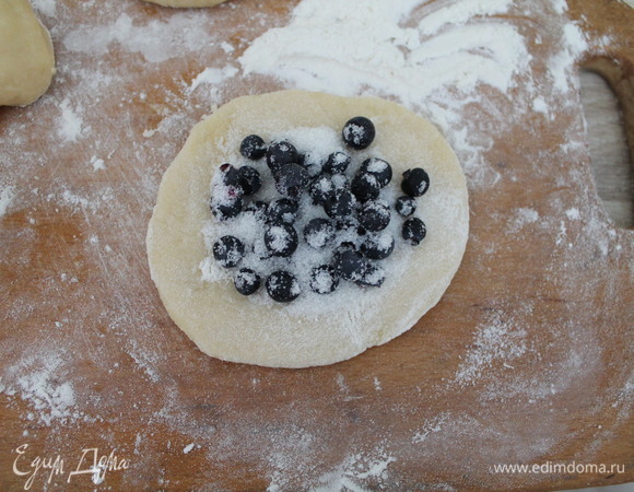 Каждый шарик раскатываем, кладем чернику и посыпаем сахаром.