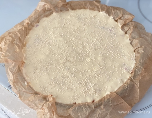 Форму для выпечки застелить пергаментом. Влить половину теста. На тесто выложить начинку и снова влить оставшееся тесто, аккуратно разровнять и посыпать сверху кунжутом. Выпекать при 180°C примерно 1 час.