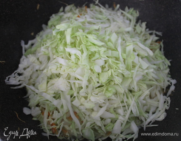 Добавляем капусту. Закрываем крышкой вок и тушим, периодически помешивая. Наливаем воды примерно 1 стакан.