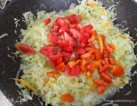 Как только капуста уменьшится в объеме, выкладываем перец и помидор. Перемешиваем.