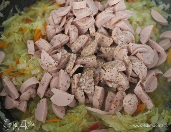 Сосиски выкладываем к овощам. Солим и перчим по вкусу. Перемешиваем.