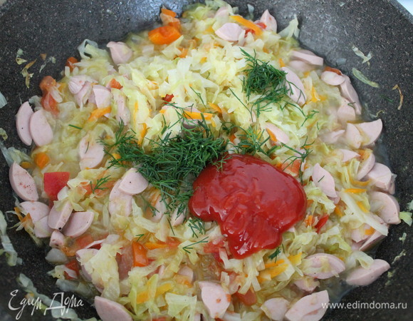 Выкладываем нарезанный укроп и добавляем кетчуп. При необходимости можно подсолить. Перемешиваем и тушим до готовности.