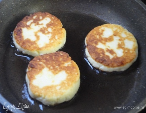 На сковороде разогреваем 1 ст. л. растительного масла, включаем средний нагрев и обжариваем сырники 3 минутки с одной стороны, затем переворачиваем, убавляем нагрев на одно деление, накрываем крышкой и готовим еще 3 минуты.