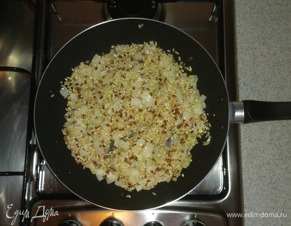 Когда репчатый лук станет мягким, то к нему нужно добавить смесь риса. Перемешать и обжарить около 2 минут.
