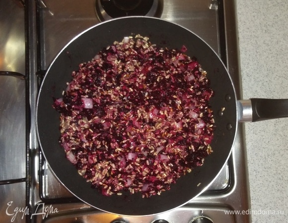 Затем вино нужно вылить на сковородку. Перемешать, убавить огонь и тушить, пока рис не впитает все вино. После этого добавить измельченную свеклу. Перемешать.