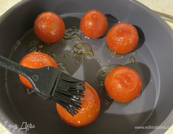 Смешиваем 2 ст. л. масла с медом и красим кисточкой помидоры. Отправляем их в духовку при 180°C на 8–12 минут (зависит от размера помидоров, у меня на фото помидоры крупнее обычных черри). Шкурка должна стать мягкой.