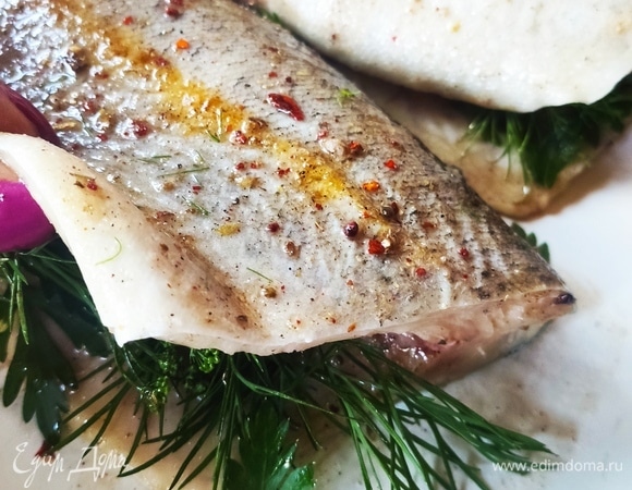 В брюшко кладем петрушку и укроп, сверху делаем надрезы и туда вставляем тонкие дольки чеснока. Отправляем в духовку буквально на полчаса.