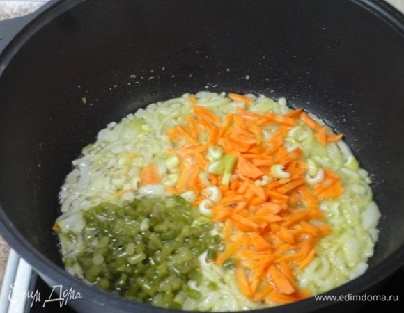 В сотейнике обжарьте 1 мелко нарезанную луковицу с морковью и чесноком. Можно использовать свежие или маринованные чесночные стрелки.
