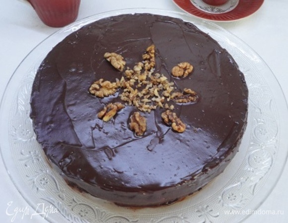 Растопите шоколад со сливочным маслом в микроволновой печи и полейте торт шоколадом. Украсьте грецкими орехами.
