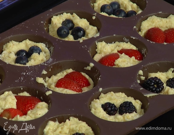 Формы для маффинов заполнить тестом на половину объема, добавить половину ягод, затем разложить оставшееся тесто и ягоды.