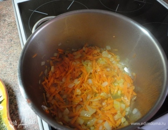 В глубоком сотейнике обжарить нарезанный кубиками лук, затем добавить натертую морковь и болгарский перец.