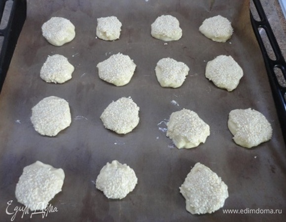 К этой жидкой смеси просеиваем муку с разрыхлителем и замешиваем тесто. Только мокрыми руками я могла брать тесто кусочками, обваливать в кунжуте и выкладывать на противень. Конечно, получились печеньки корявенькие, но...