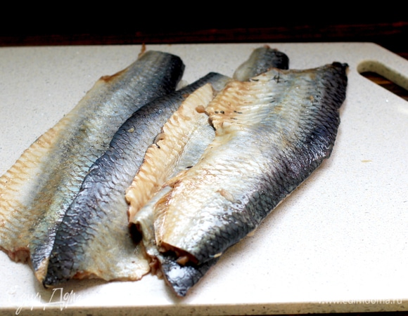 Если сельдь целиковая, разделываем ее, филируем, солим, перчим.