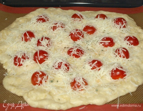 Сыр натереть на мелкой терке. Помидоры черри разрезать на две половинки. Раскладываем помидоры на лепешке в художественном беспорядке, посыпаем тертым сыром.