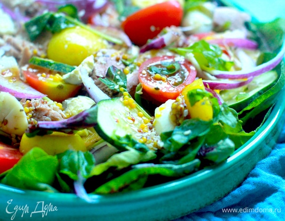 Отварить предварительно яйца, картофель в кожуре. Остудить, очистить. Картофель нарезать кружками и слегка обжарить на сливочном масле до золотистой корочки, в конце добавить чеснок, пропущенный через пресс. Огурец нарезать кружками, черри — пополам, лук — перьями. С тунца слить сок, разделить руками на кусочки.