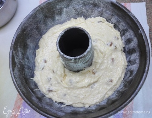 В яично-масляную смесь просейте сухие ингредиенты и высыпьте молотый миндаль. Перемешайте. В этой форме у меня дно прилипло. Поэтому лучше, как всегда, использовать разъемную форму диаметром 23 см. Застелите дно пекарской бумагой, смажьте ее и бока формы маслом. Выложите половину теста. Подмешайте в оставшуюся половину изюм и выложите сверху.