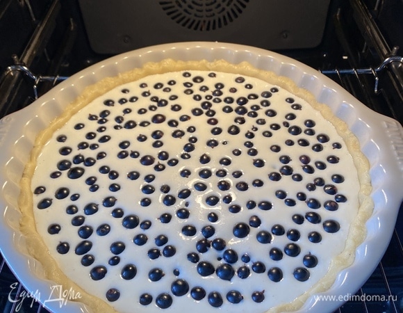 Затем достать, вылить творожную массу, выложить сверху черную смородину и поставить выпекаться в заранее разогретую до 180°C духовку.