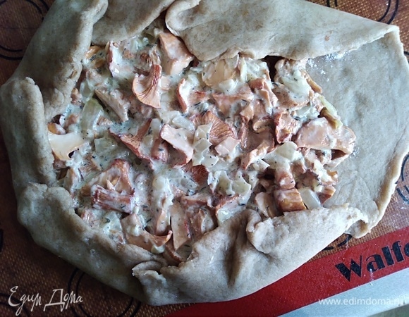 Раскатать тесто толщиной около 0,5 см. Посыпать крахмалом. Выложить начинку на середину и завернуть края. Поставить в разогретую духовку. Выпекать 20 минут, потом посыпать тертым сыром и готовить еще 15–20 минут.