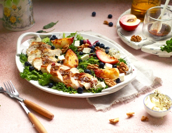 На блюдо выложить салатные листья, на них — филе, орехи, чернику, фету и дольки нектаринов.