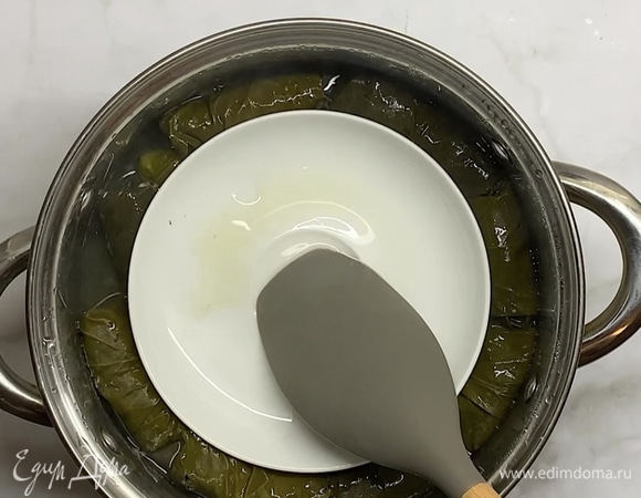 Поверх кладем тарелку, чтобы листики не развернулись при варки. Накрываем крышкой и варим около 1 часа на небольшом огне.