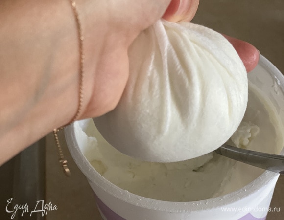 Греческий йогурт выкладываем в плотное полотенце или в несколько слоев марли. Берем небольшую часть, потому что отжимать 1 кг йогурта за один раз тяжело. Отжимаем что есть сил, чтобы убрать жидкость.
