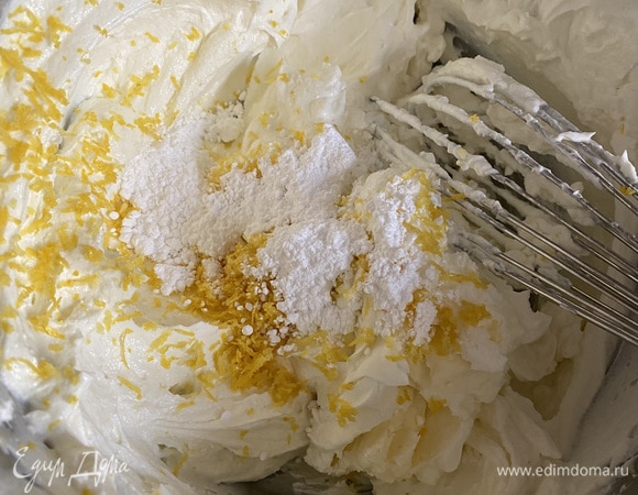 Соединяем в одной емкости сыр и йогурт. Туда же натираем на мелкой терке цедру одного лимона. Добавляем сахарную пудру. Перемешиваем венчиком. Накрываем пленкой и оставляем в стороне.