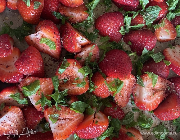 Клубнику моем, режем вдоль, выкладываем на противень. Посыпаем приправой сумах по желанию. Руками мелко рвем листики мяты и посыпаем клубнику. Сверху посыпаем сахаром. Доливаем 0,75 стакана воды. Отправляем в духовку примерно на 20 минут при 200°C. Запекаем до красоты и аромата. Как только отправили клубнику в духовку, отправляем наш крем в морозилку.