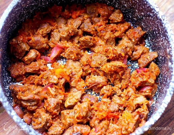 В сотейнике растопить сливочное масло, добавить растительное, обжарить 4–5 минут на большом огне кусочки вареного мяса до золотистой корочки. Добавить лук, чеснок, специи и жарить до готовности лука. Добавить протертые помидоры, томите минут 5–6, помешивая мясо, оно должно обволакиваться овощным соусом.