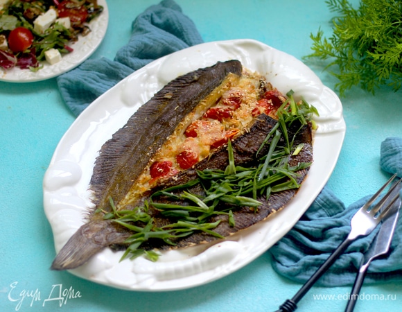 На масле обжариваем нашинкованный порей, выкладываем его в разрез камбалы равномерно, далее — нарезанные пополам черри. Посыпаем сыром. Можно слегка посыпать солью и измельченной зеленью.