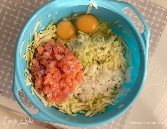 Кабачки натереть на крупной терке. Если они слишком сочные, отжать массу. Добавить яйца, мелко нарезанный лук, чеснок, черный перец, соль и нарезанную мелким кубиком красную рыбу.