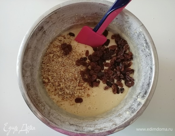 Немного орехов оставляем, остальные добавляем в тесто, туда же отправляем изюм. Перемешиваем.