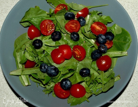 Салат заранее промыть и дать стечь воде. Помидоры черри разрезать на две половинки. В тарелку кладем салат, добавляем помидоры черри и голубику.