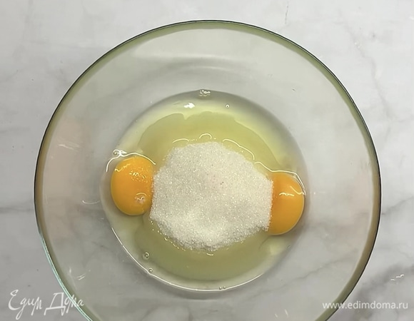 В яйца добавляем сахар и 1 щепотку соли, перемешиваем венчиком.